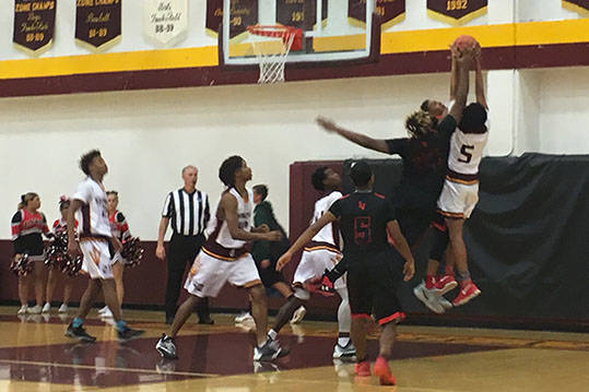 Eldorado and Las Vegas High players fight for the ball during their boys basketball game at ...