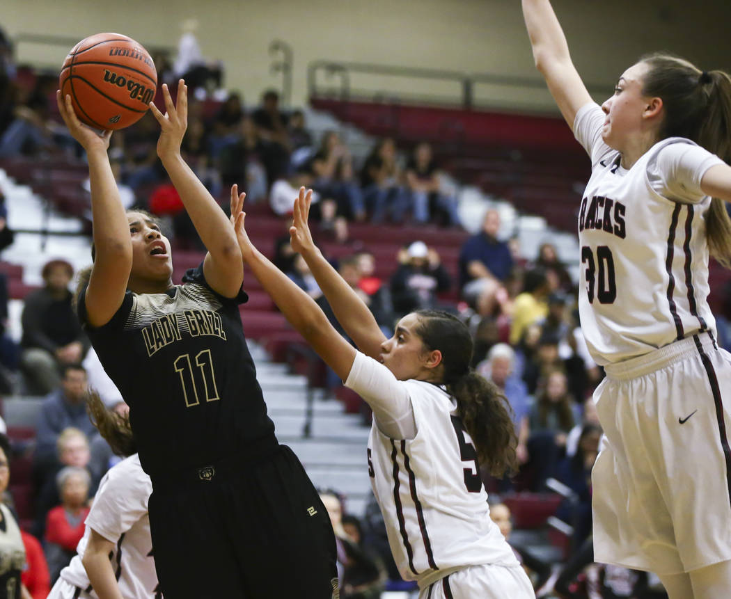 Spring Valley’s Kayla Harris (11) shoots over Desert Oasis’ Eliyjah Pricebrooks ...