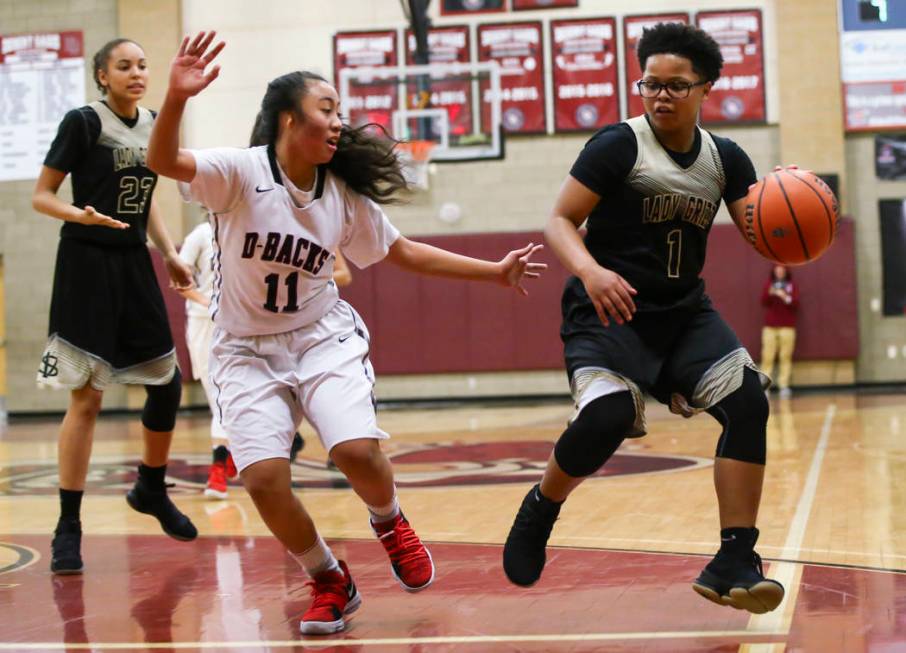 Spring Valley’s Deja McDonald (1) drives against Desert Oasis’ Kalena Halunajan ...