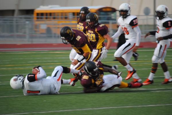 Devontae Brown (22) , A.J. Segura (12), Scott Maughan (30)  and Chad Uyeno (52) surroun ...