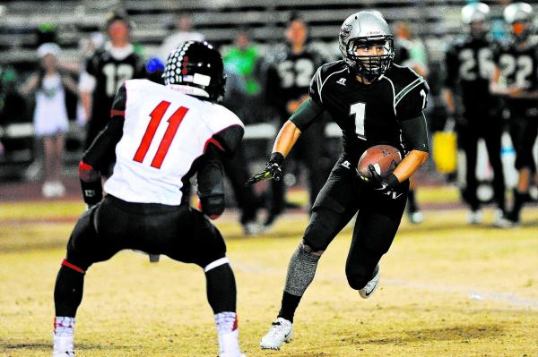 Green Valley’s Giovanni Hernandez (1) looks for running room against Las Vegas defende ...