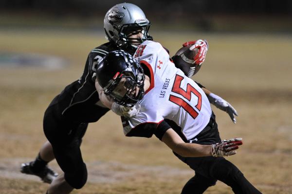 Green Valley’s Albert Lake (23) brings down Las Vegas receiver Sam Blackburn (15) on F ...