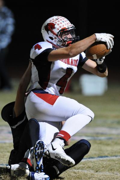 Coronado’s Michael Simpson (4) drags Foothill defender Vincent Mondungo (20) into the ...