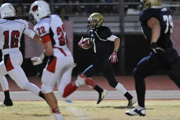 Foothill’s David Persi (11) looks for running room against Coronado’s Jad Cheeta ...