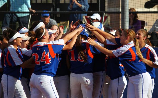 Teammates surround Bishop Gorman’s Shelby Estocado (15) after her fifth-inning home ru ...