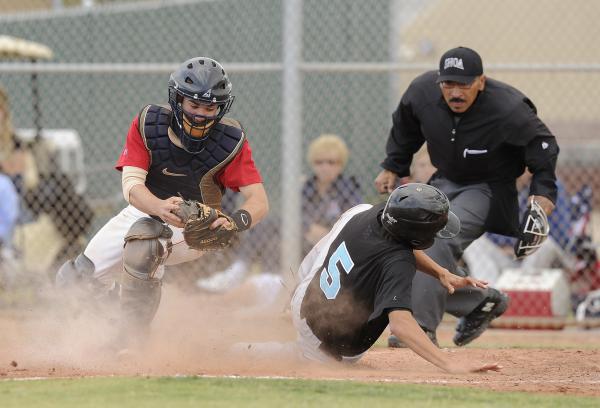 Silverado’s Nick Kawano slides under the tag of Liberty catcher Joseph Maurer to score ...