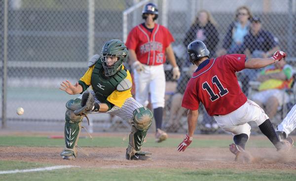 Liberty center fielder Preston Pavlica scores as Rancho catcher Zach Barnhart awaits the thr ...