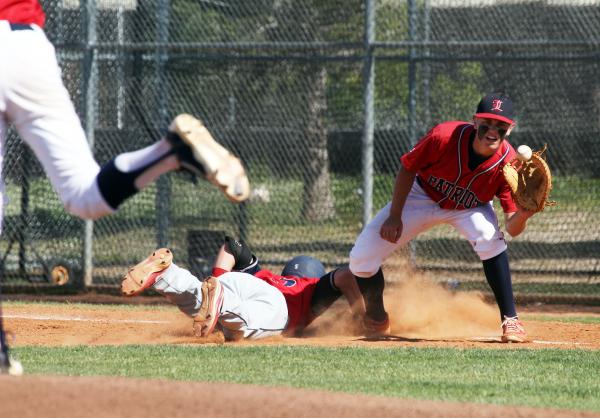 Coronado’s James Anderson dives safely back to first as Liberty’s Josh McCollum ...