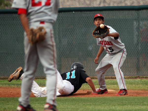 Las Vegas first basebam Eddie Ojeda takes a throw as Silverado’s Vincent Taormina dive ...