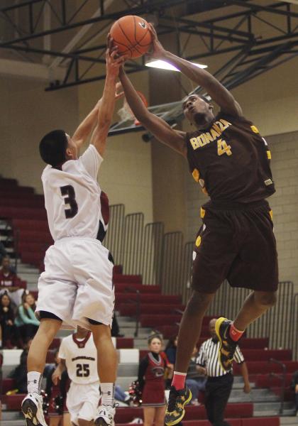 Desert Oasis’ Jay Esguerra (3) and Bonanza’s DaVonta Price (4) battle for a loos ...