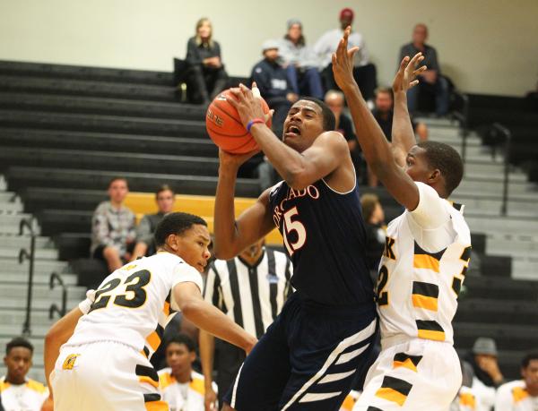 Coronado’s Nick Howard (15) attempts a shot as Clark’s Deshawn Wilson (23) and J ...