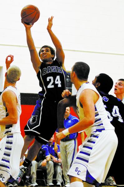 Basic’s Chandler Kamai (24) shoots over Graves County’s Eamon Hannon, left, and ...