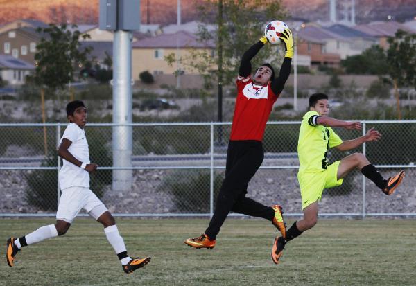 Liberty goalie Joey Schibetta reaches up for a save as Green Valley’s Roberto Rodrigue ...