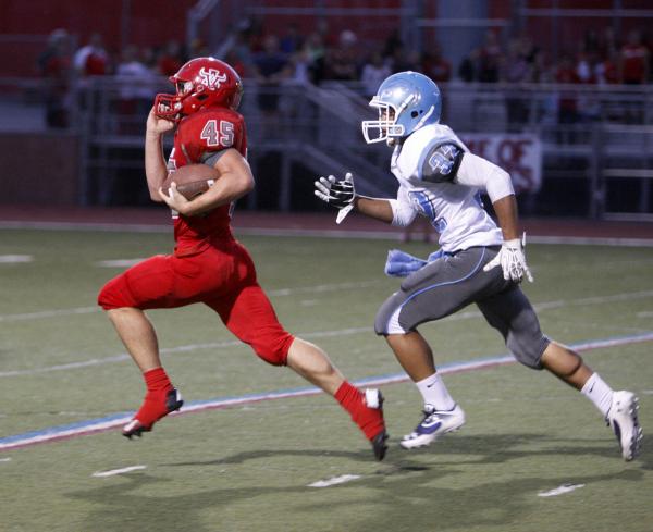 Arbor View running back Ricky Clark runs ahead of Centennial defensive back Samuel Liaga for ...