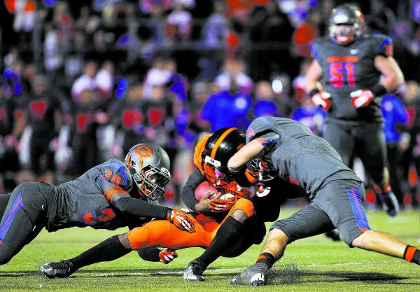 Bishop Gorman’s Dylan Weldon (30) and Nico Fertitta (4) converge on Booker T. Washingt ...