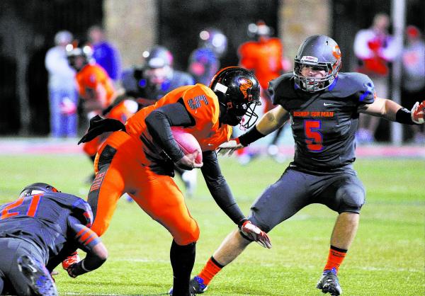 Bishop Gorman’s Kenyan Coker (21) and Ryan Garrett (5) converge on Booker T. Washingto ...