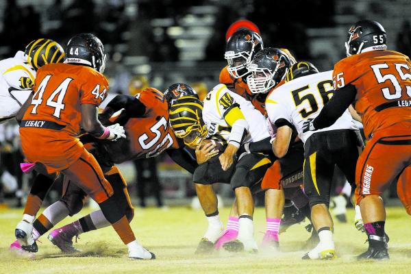 Legacy’s Josh Phillips (50) and teammates converge on Bonanza quarterback Tyler Penkal ...