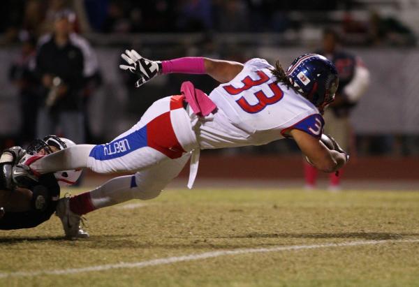 Liberty’s Brenan Adams (33) leans across the goal line to score in a 45-27 win over Co ...