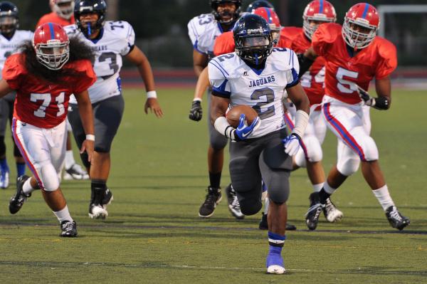 Desert Pines running back Eric Wilkes (2) breaks free from Valley defenders Fernando Solorio ...