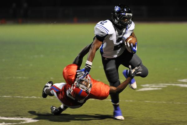 Desert Pines running back Eric Wilkes (2) stiff arms Valley defender Malik Batiste (21) on T ...