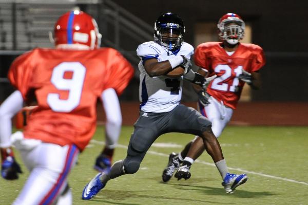 Desert Pines Tim Hough (4) cuts through Valley defenders Iyen Medlock (9) and Malik Batiste ...