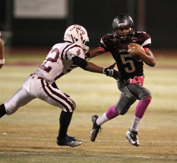 Cimarron-Memorial quarterback Derek Morefield runs past Desert Oasis defensive back Kyle Jen ...