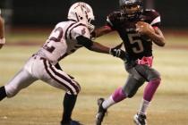 Cimarron-Memorial quarterback Derek Morefield runs past Desert Oasis defensive back Kyle Jen ...