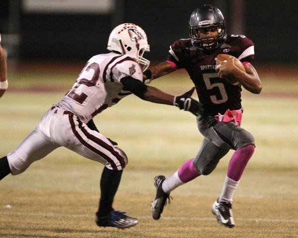 Cimarron-Memorial quarterback Derek Morefield runs past Desert Oasis defensive back Kyle Jen ...