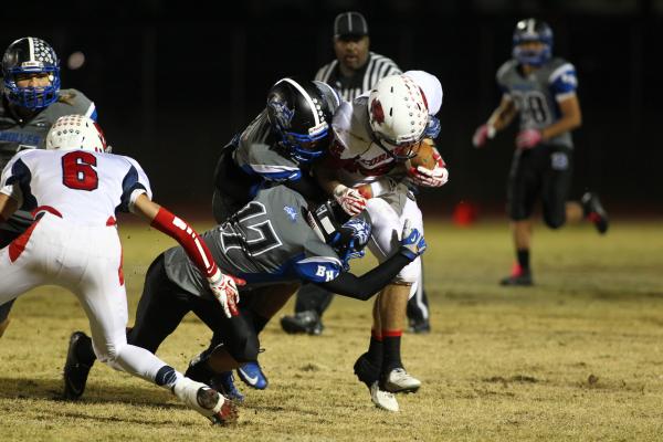 Basic players take down Coronado’s Tanner Bellamy on Friday.