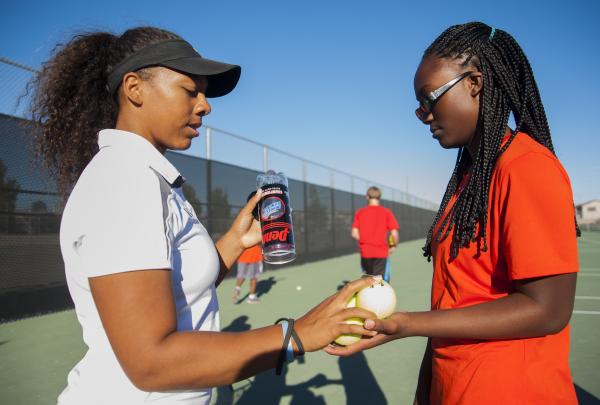 Hannah Tatlock, left, hands new tennis balls to Eva Sampson before a recen match with Wester ...