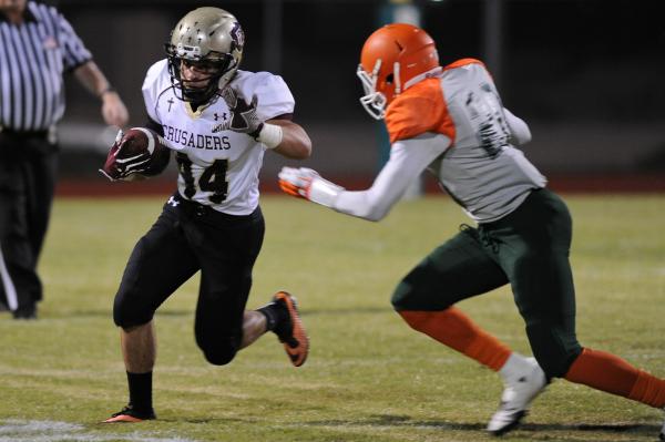 Faith Lutheran’s Fabian Lagudi (44) tries to run past Mojave’s Eric Snyder (20) ...