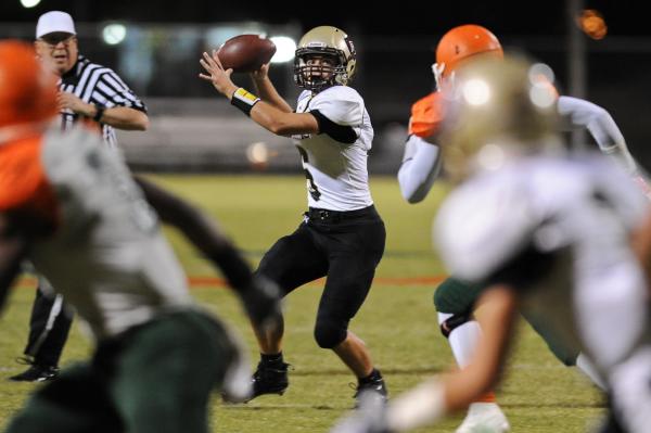 Faith Lutheran’s Jacob Deaville (6) looks for a receiver during a football game agains ...