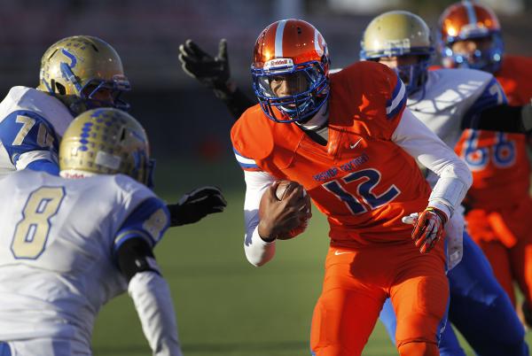 Bishop Gorman quarterback Randall Cunningham (12) looks for running room between Reed’ ...