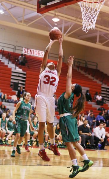 Arbor View junior Janae Strode (32) goes up for a shot as Green Valley sophomore Gwen Garcia ...