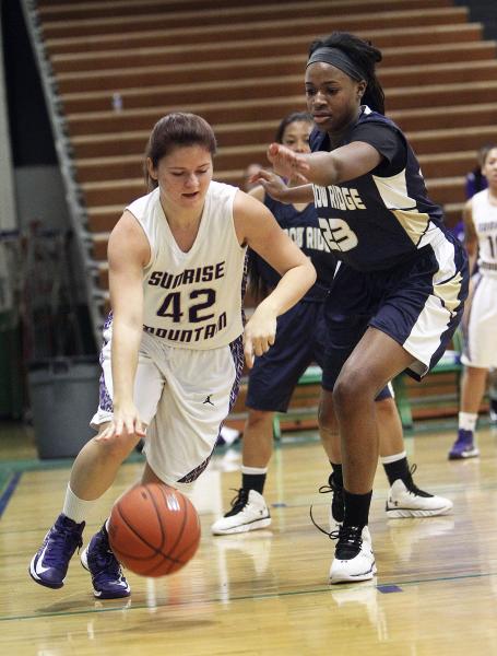 Sunrise Mountain’s Jennifer Smith (42) drives around Shadow Ridge’s Assana King ...