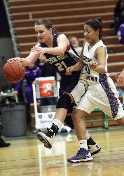 Shadow Ridge’s Kaila Hurley tries to keep the ball inbounds while being bumped by Sunr ...