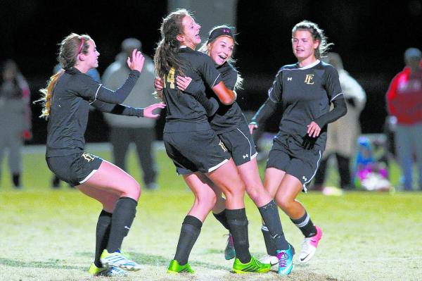 Faith Lutheran’s Charlotte Vancura (14) hugs teammate Kristi Chinn after the Crusaders ...