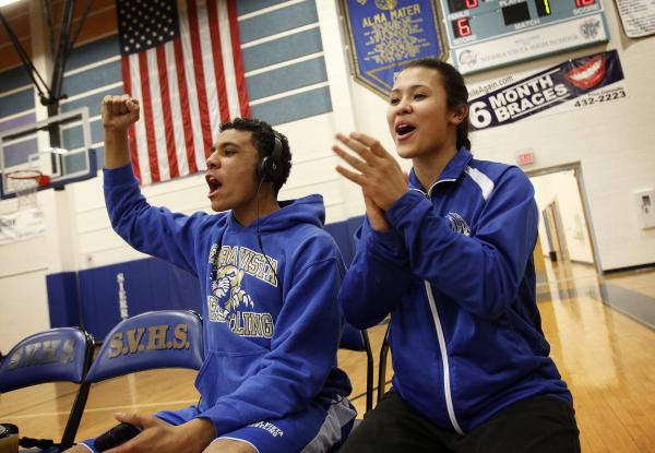 Sierra Vista wrestlers Caroline Sauder, right, and Marcus Polk cheer on a teammate during a ...