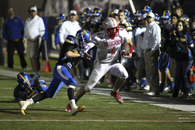 Truckee High School football player Erik Holmer (4) gets pushed towards the sidelines by Moa ...