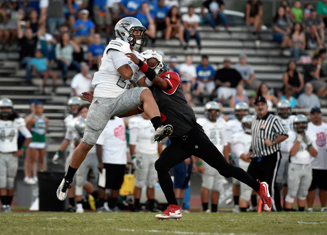 Green Valley’s Christian Mayberry, left, makes a reception over Las Vegas’ Zacha ...