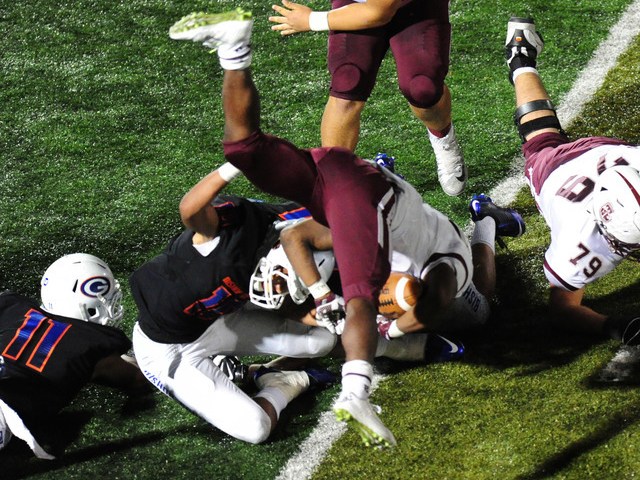 Don Bosco Prep Ironmen running back Malik Bakker is upended by Bishop Gorman linebacker Pala ...