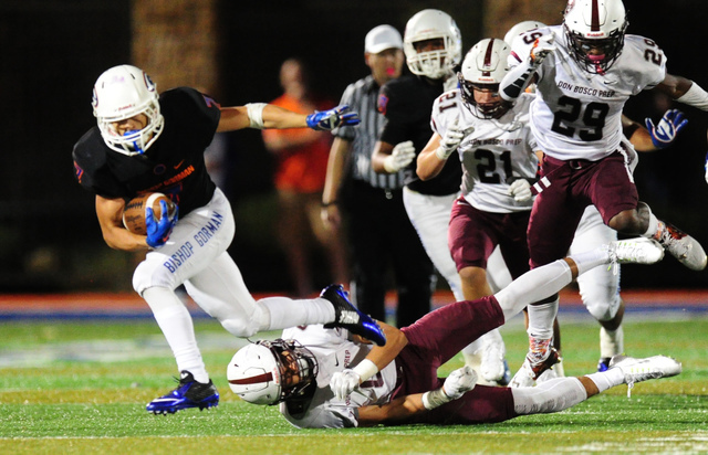 Bishop Gorman running back Biaggio Ali Walsh (7) breaks the tackle of Don Bosco Prep Ironmen ...