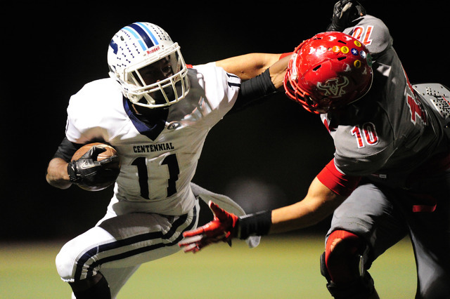 Centennial wide receiver Savon Scarver (11) stiff-arms Arbor View linebacker Bishop Jones wh ...