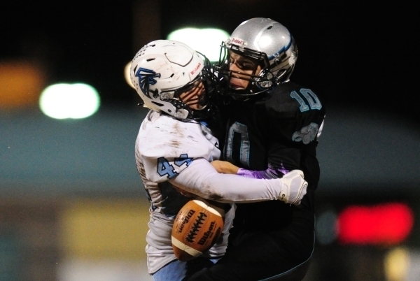 Silverado quarterback Micah Weber fumbles as Foothill linebacker Kealil Maruyama (44) tackle ...