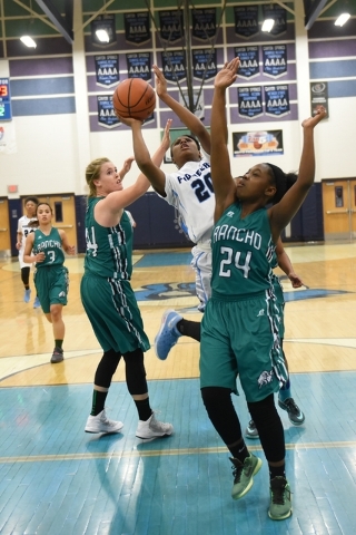 Canyon Springs Alexa Thrower (20) goes up for a shot against Rancho defenders Samantha Pocho ...