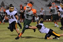 Mojave running back Ty Flanagan breaks away from Boulder City cornerback Sam Woodbury, right ...