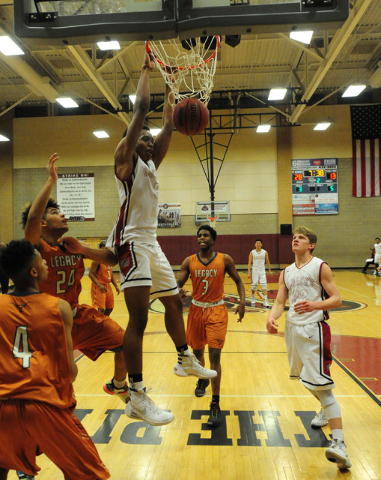 Desert Oasis forward Aamondae Coleman (5) dunks in front of Legacy forward Frank Robinson in ...