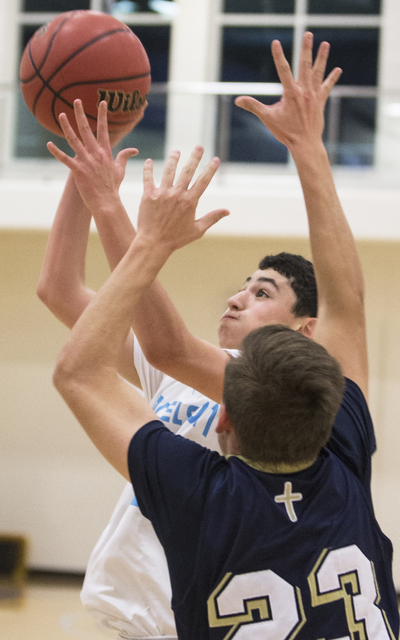 Adelson School’s Liddor Bega (23) shoots over Lake Mead’s Daniel Percival (23) d ...