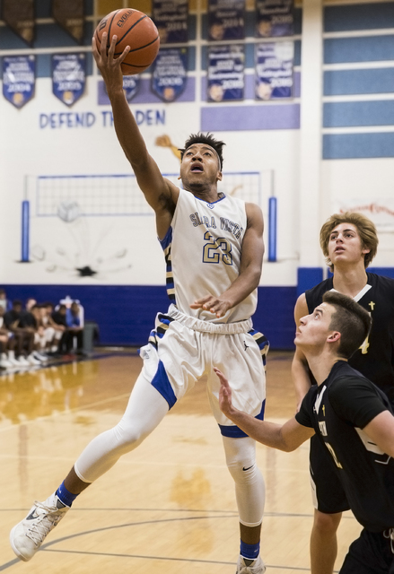 Sierra Vista’s Chris McCoy (23) slashes to the rim past Faith Lutheran defenders on Tu ...