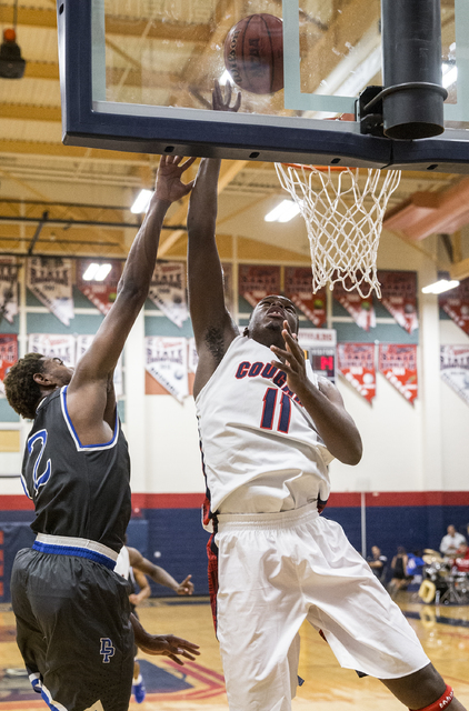 Coronado’s Will Weems (11) drives to the basket past Desert Pines’ Derrick Colem ...